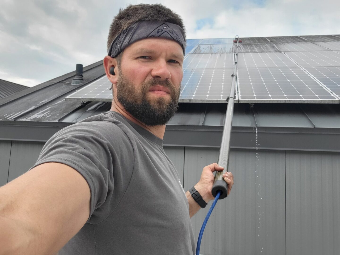 A man holding an electric pole in front of a building.