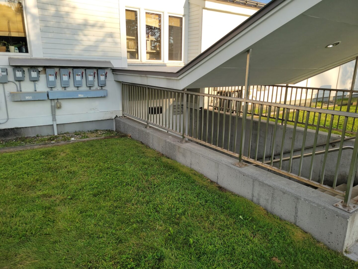 A house with grass and metal railing.
