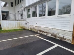 A white building with windows and a parking lot.