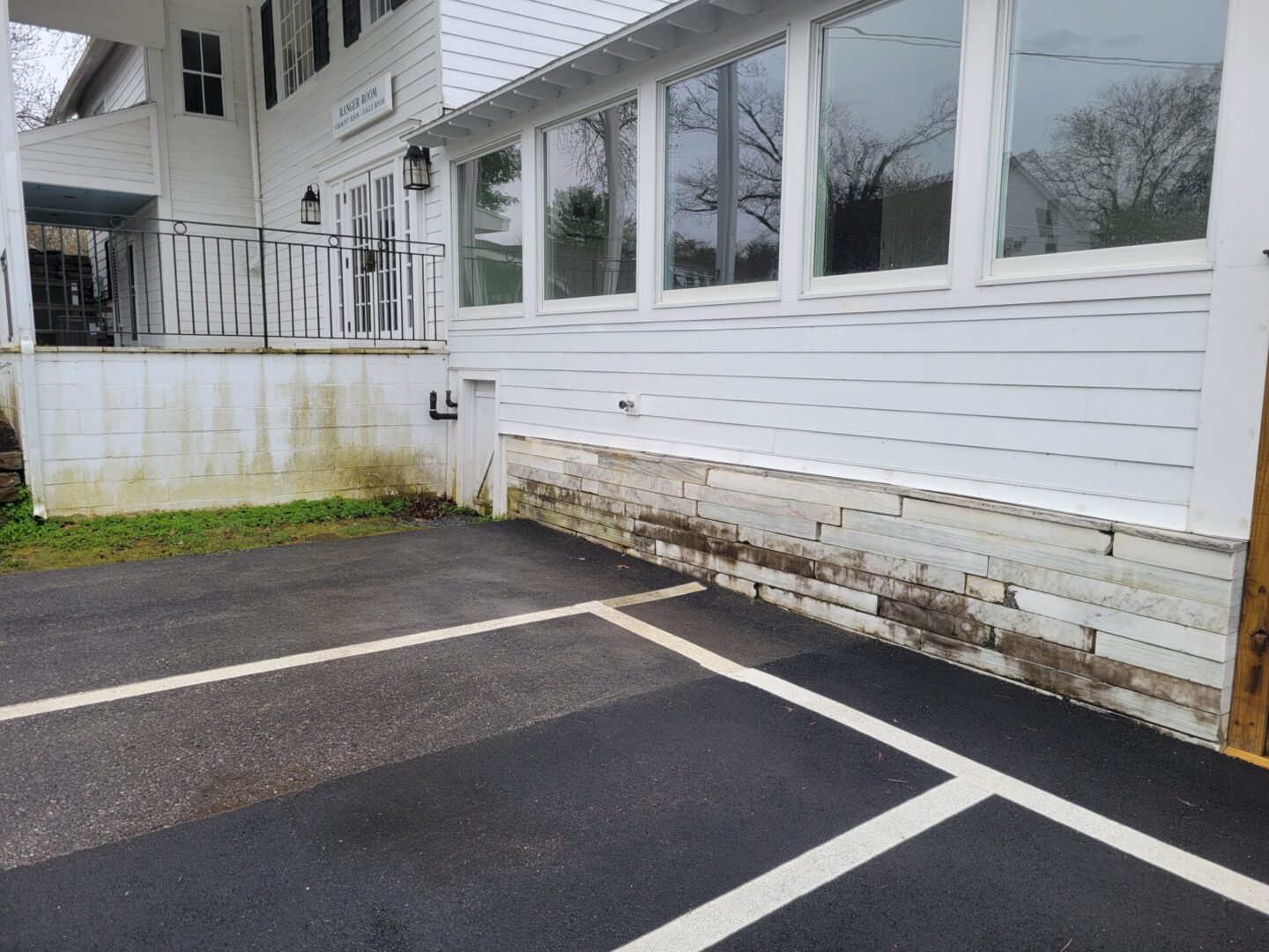 A white building with windows and a parking lot.