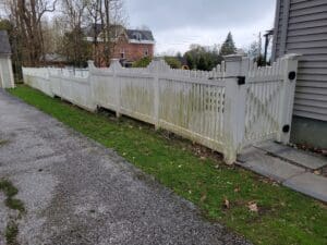 A fence that has been cleaned and is in the grass.