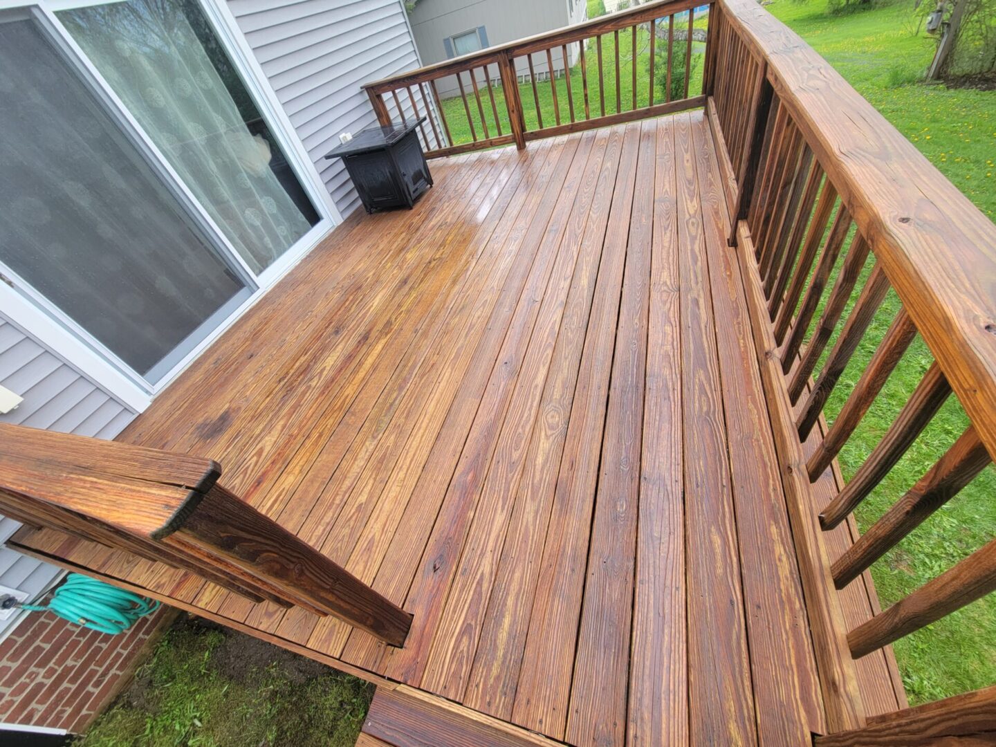 A wooden deck with a bench and railing.
