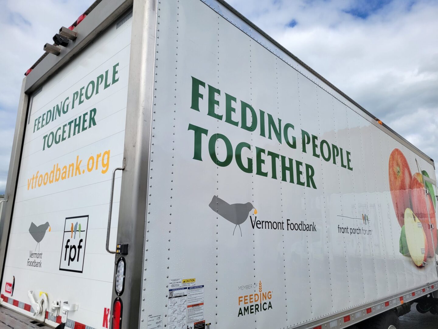 A white truck with the words " feeding people together ".