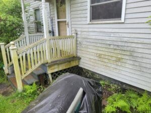 A house with a tarp on the front of it.