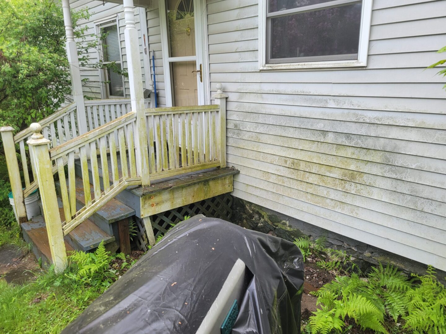 A house with a tarp on the front of it.