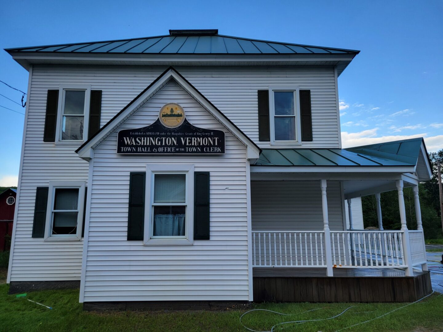 A white house with a blue roof and a sign on the front.