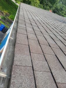 A roof with gutter and shingles on it