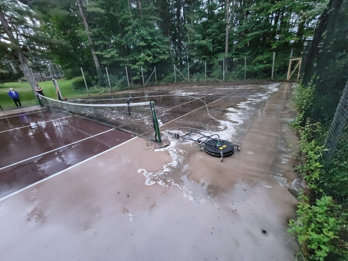 A tennis court with water running down the middle of it.
